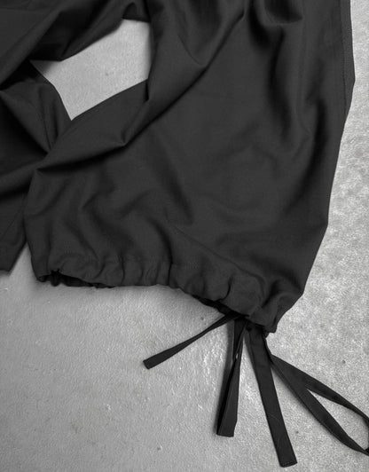 Black pants with drawstring on a gray surface