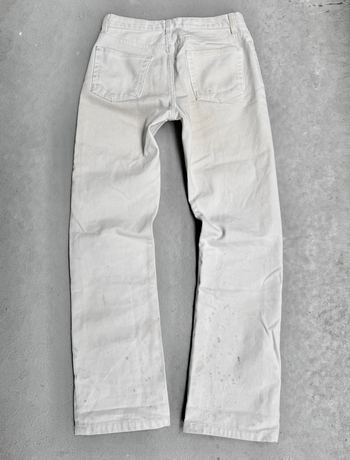 Light-colored jeans on a gray concrete surface