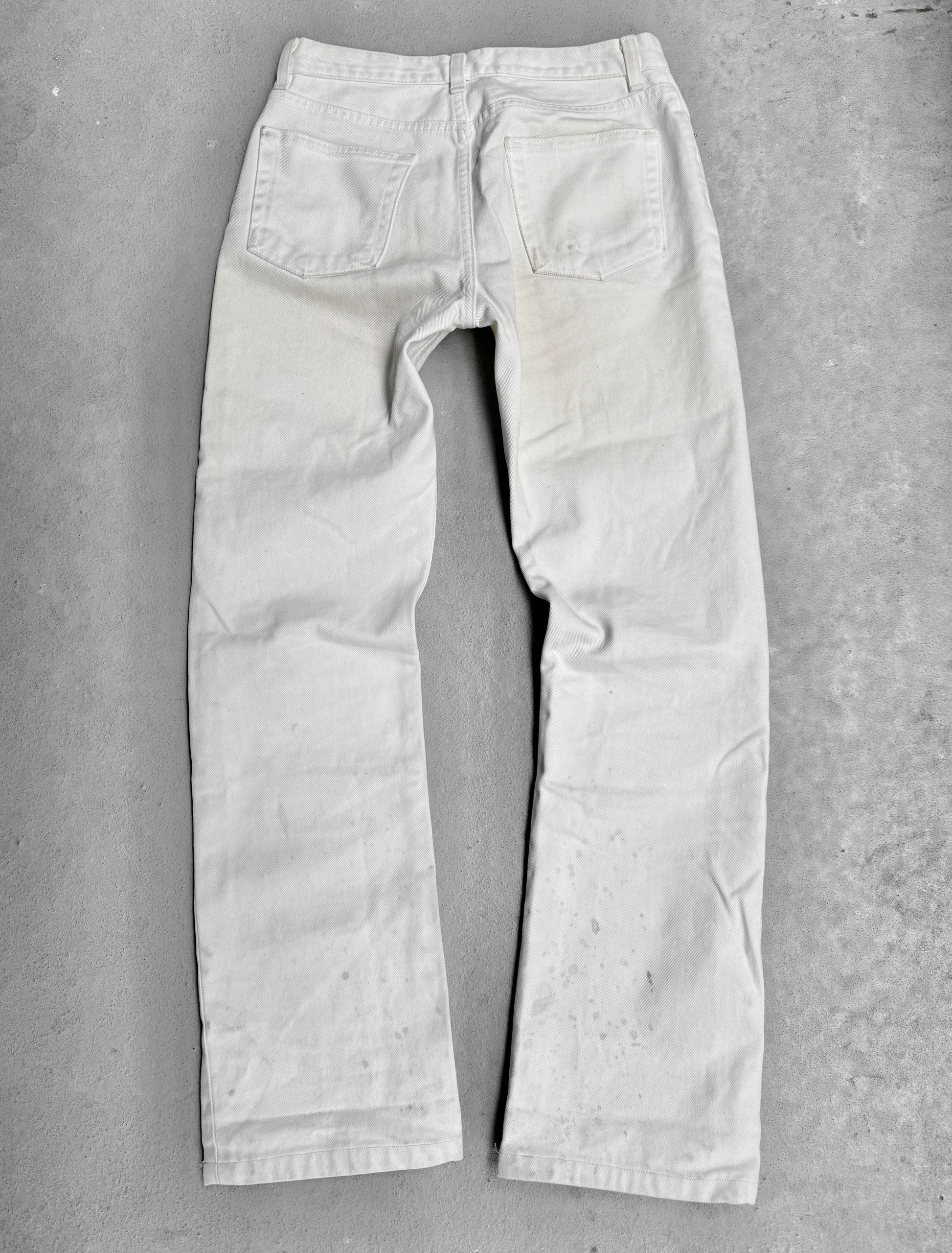 Light-colored jeans on a gray concrete surface