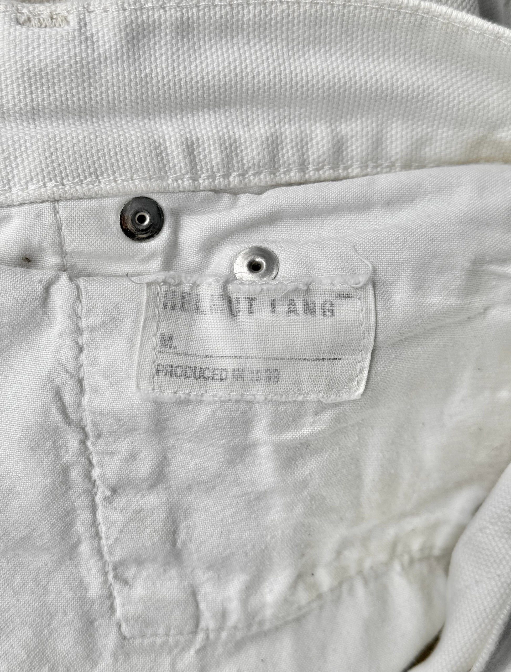 Close-up of a label on a white jacket with 'Helmut Lang' branding.