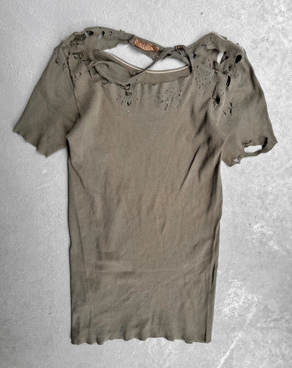 Ripped green t-shirt on a textured gray background