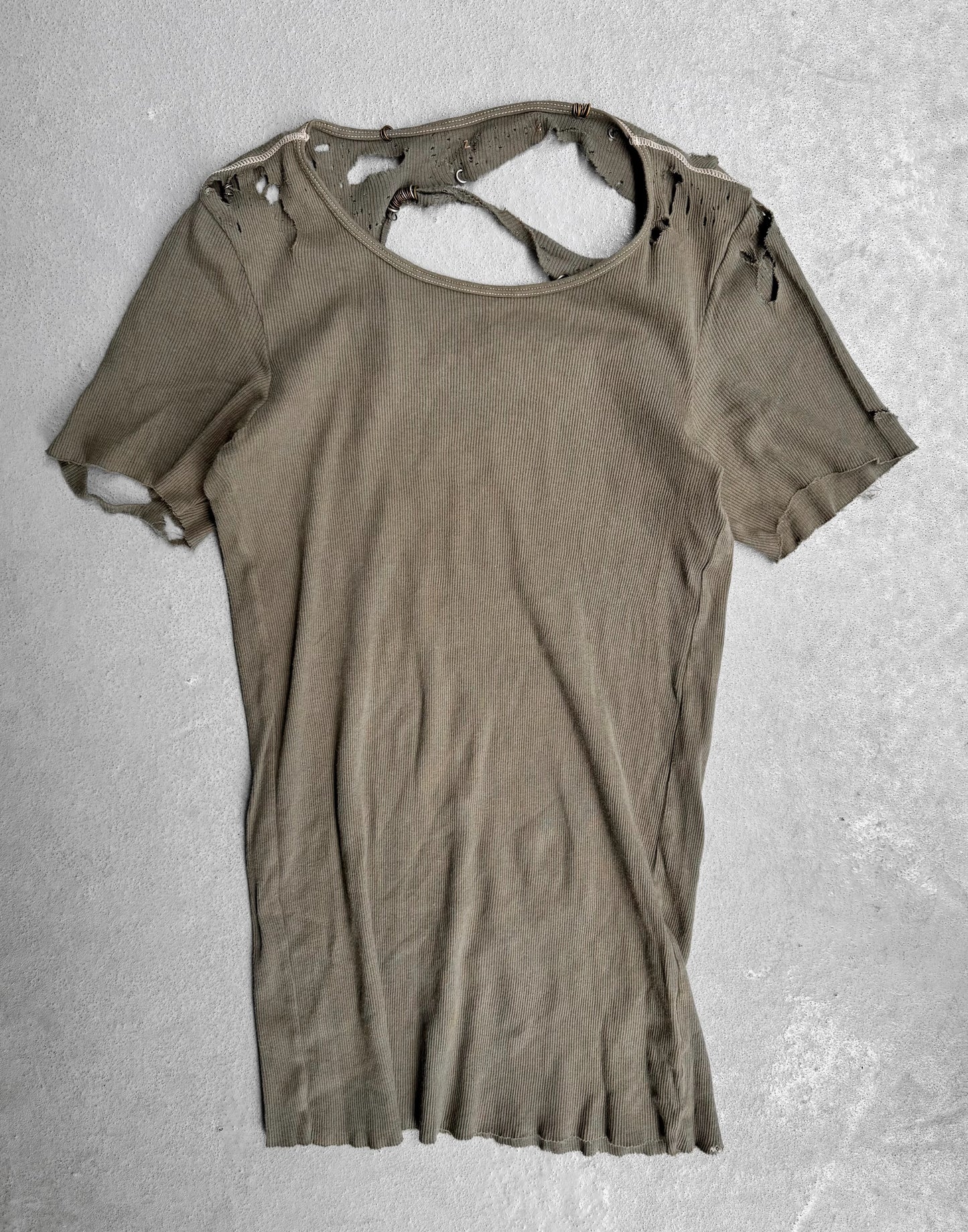 Ripped brown t-shirt on a textured gray background