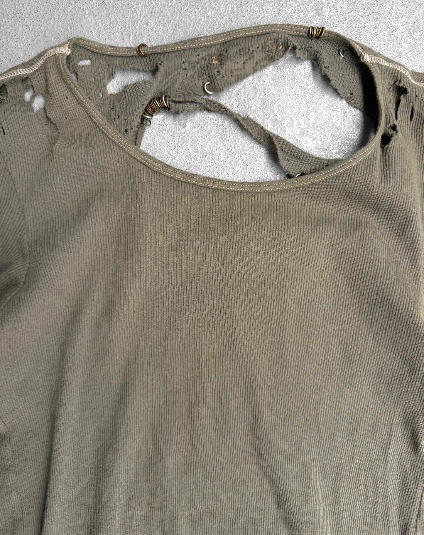 Brown tank top with visible wear and tear on a textured gray background