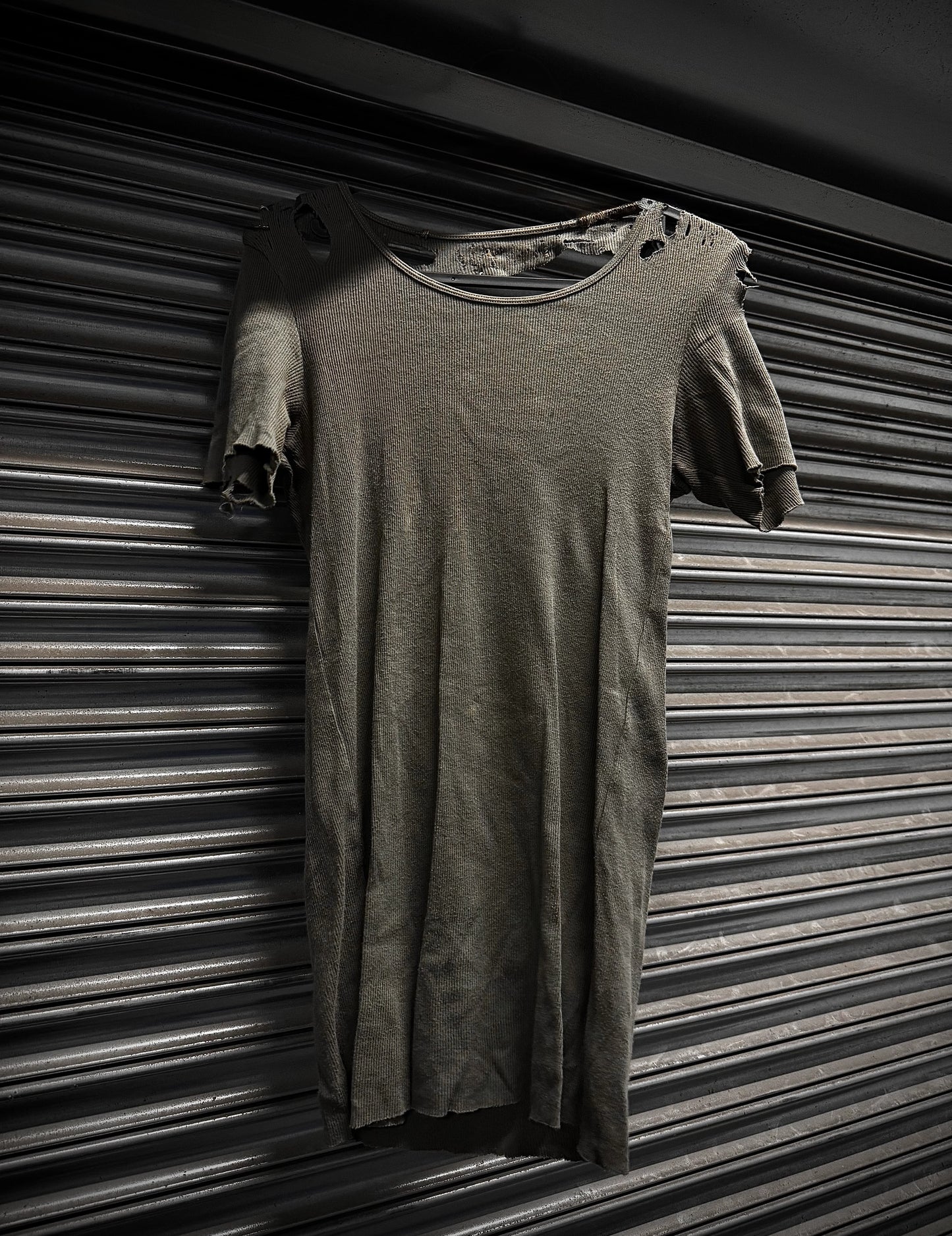 Long-sleeve shirt draped over a short-sleeve shirt against a striped background