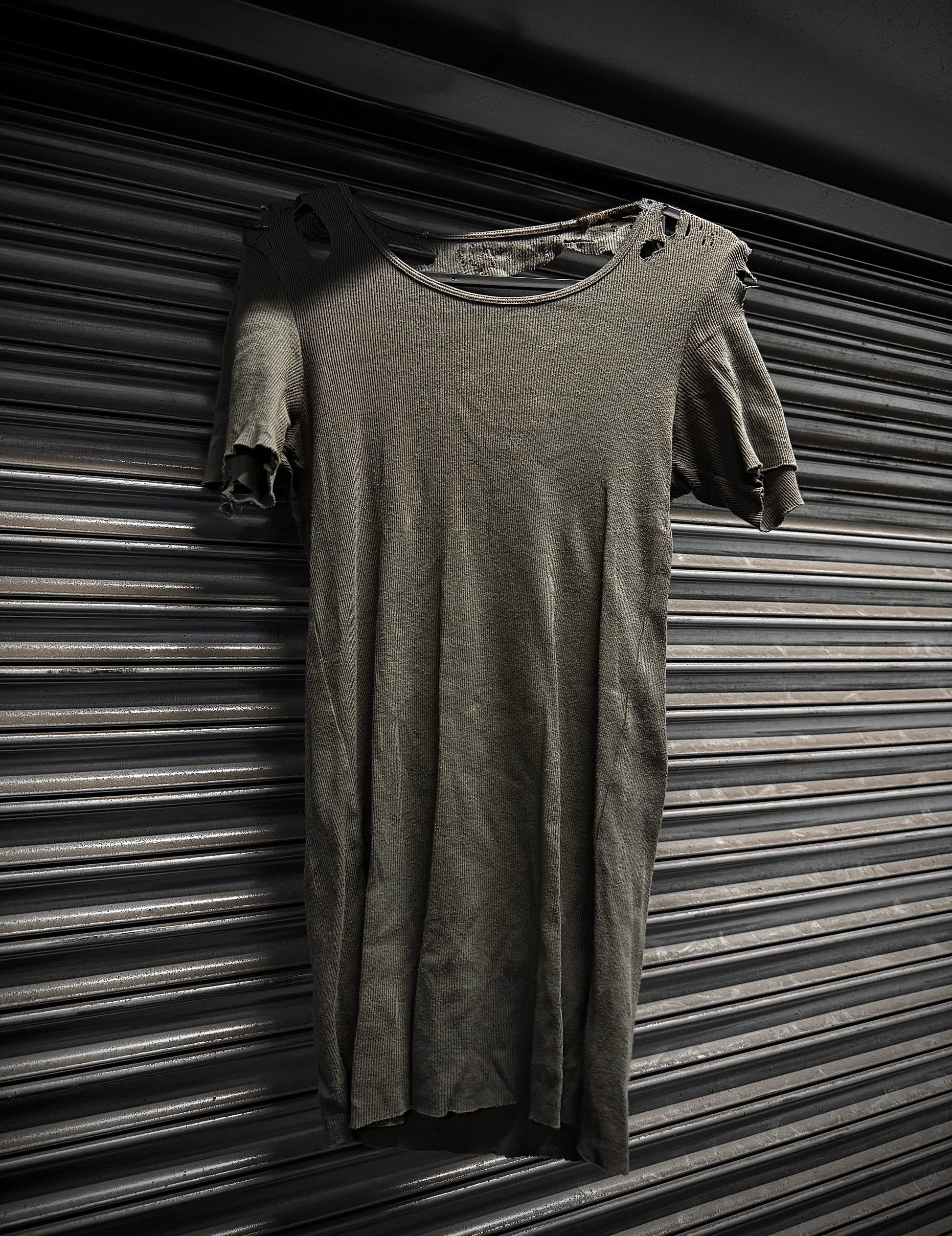 Long-sleeve shirt draped over a short-sleeve shirt against a striped background