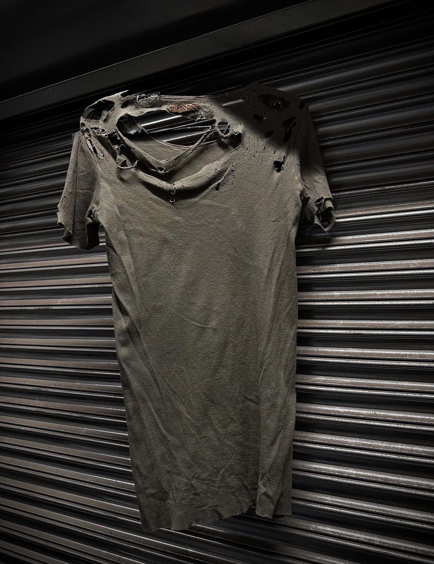 Ripped t-shirt against a corrugated metal background