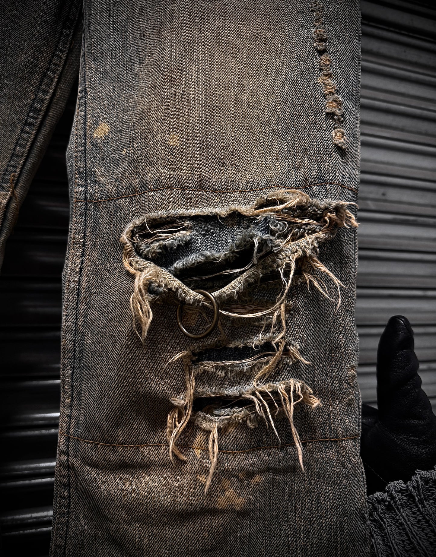 Rustic, worn leather jacket with frayed edges and a metal background
