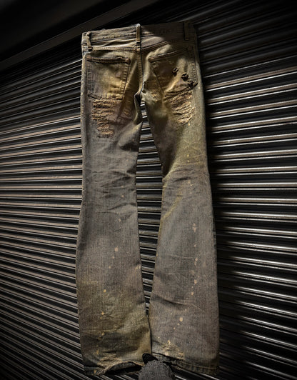 Worn denim jeans against a metallic background