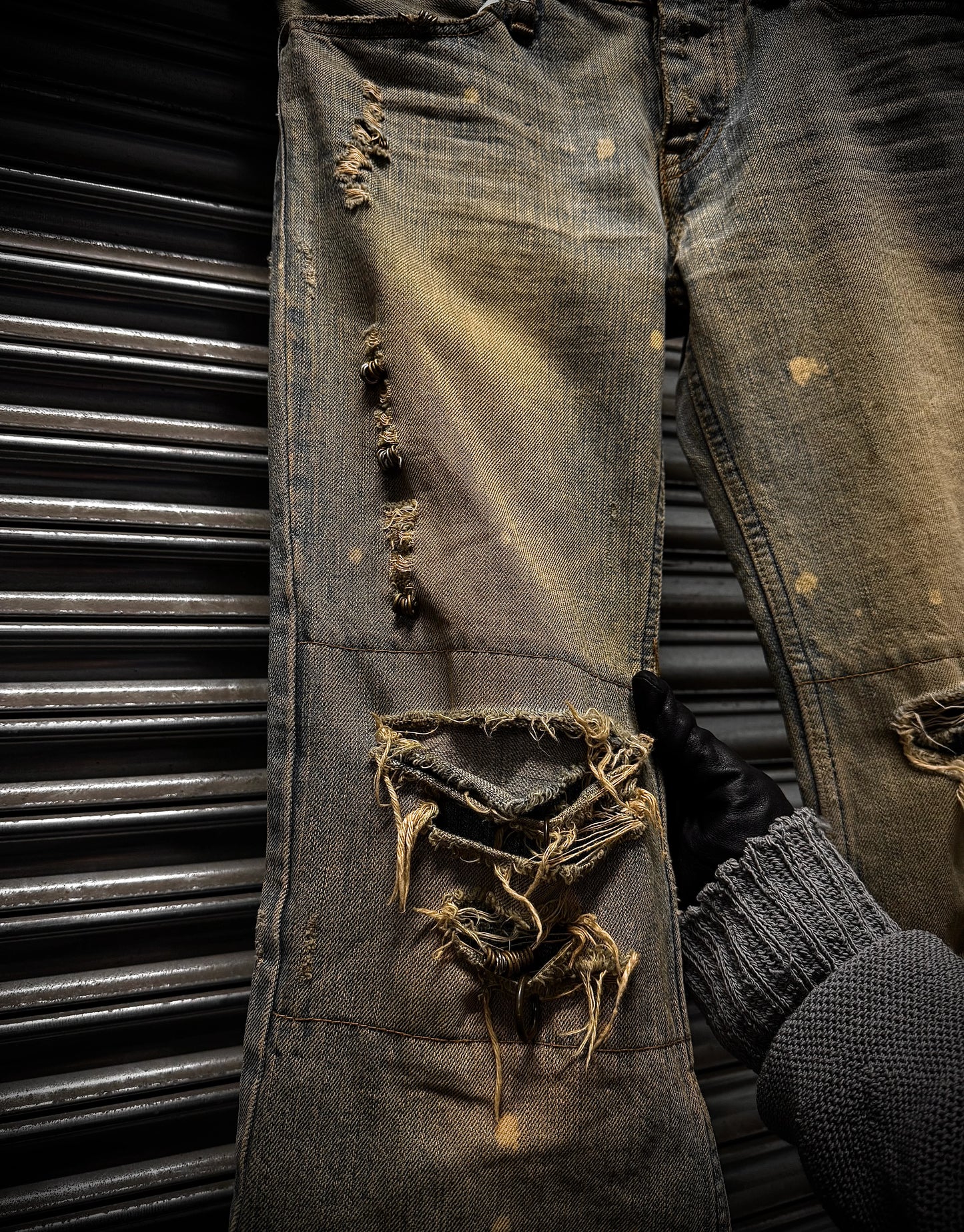 Ripped and worn denim jeans with a dark background