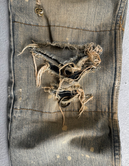Ripped pocket of a worn denim jacket on a gray background