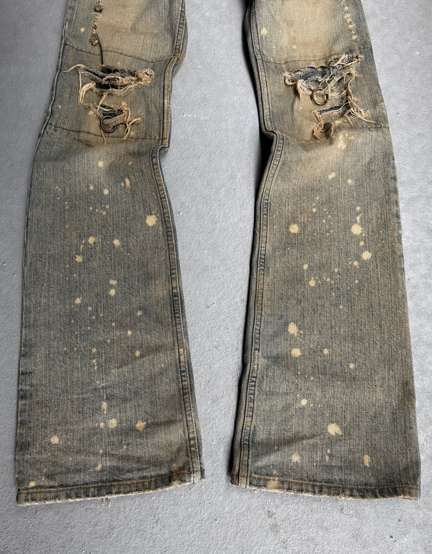 Pair of distressed jeans on a gray background