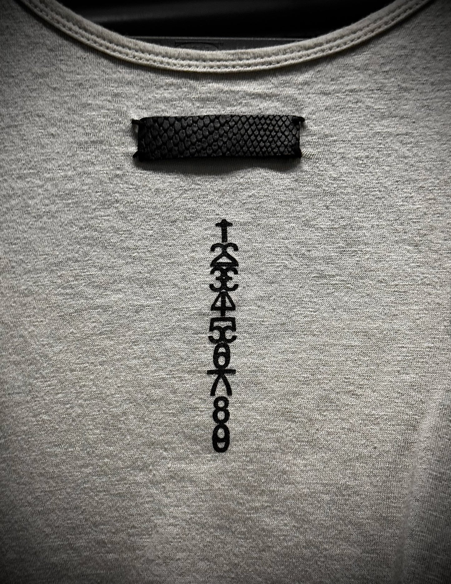 Gray sweatshirt with a black embroidered design on the chest.