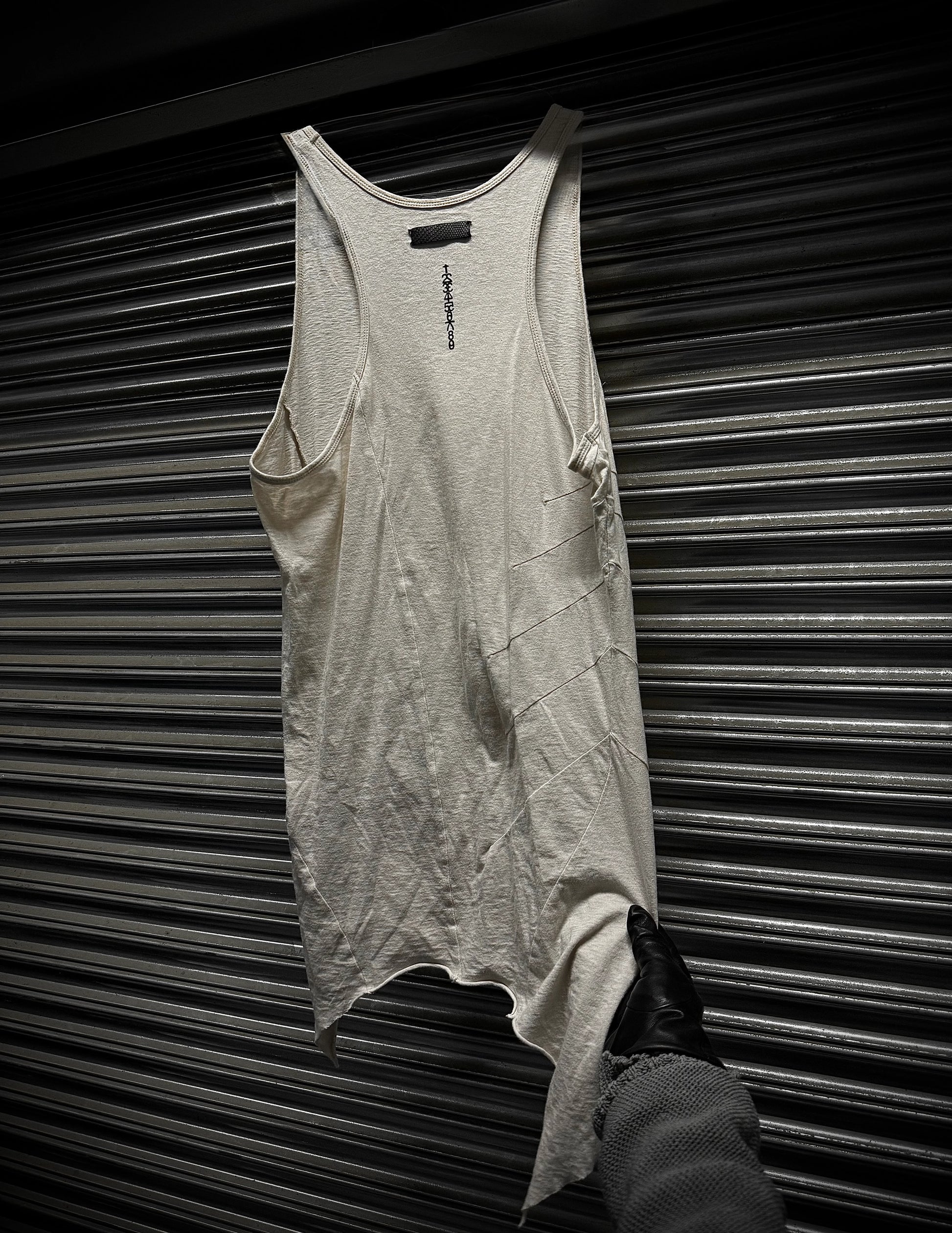 Gray tank top hanging against a metallic background