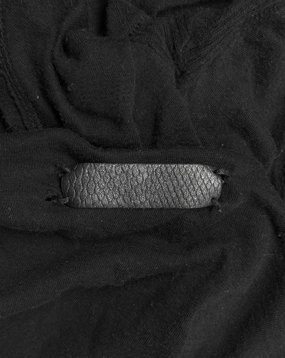 Close-up of a black leather strap on a textured black fabric background