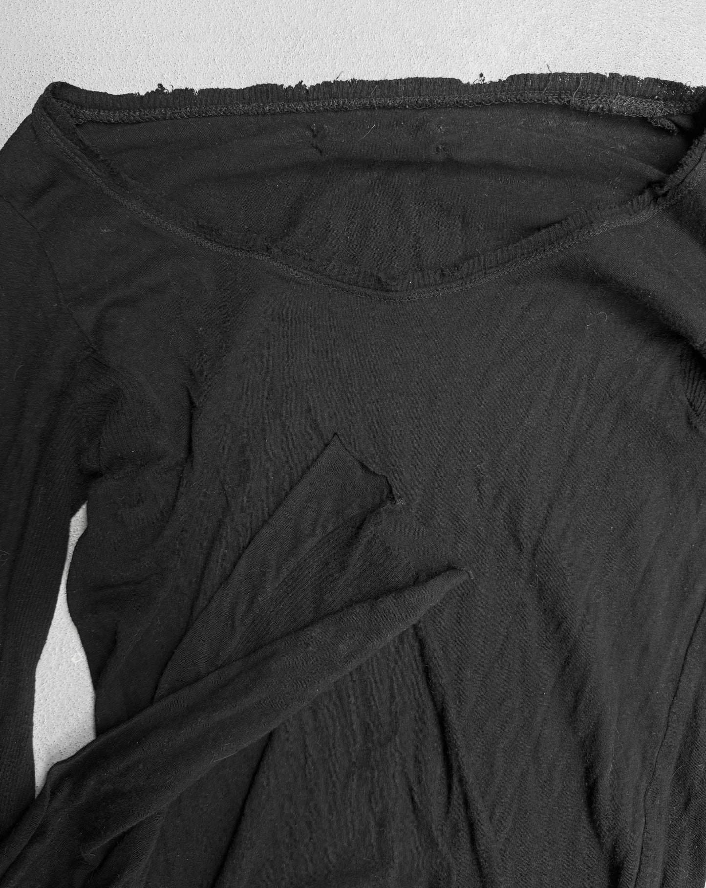 Close-up of a black long-sleeve shirt on a white background