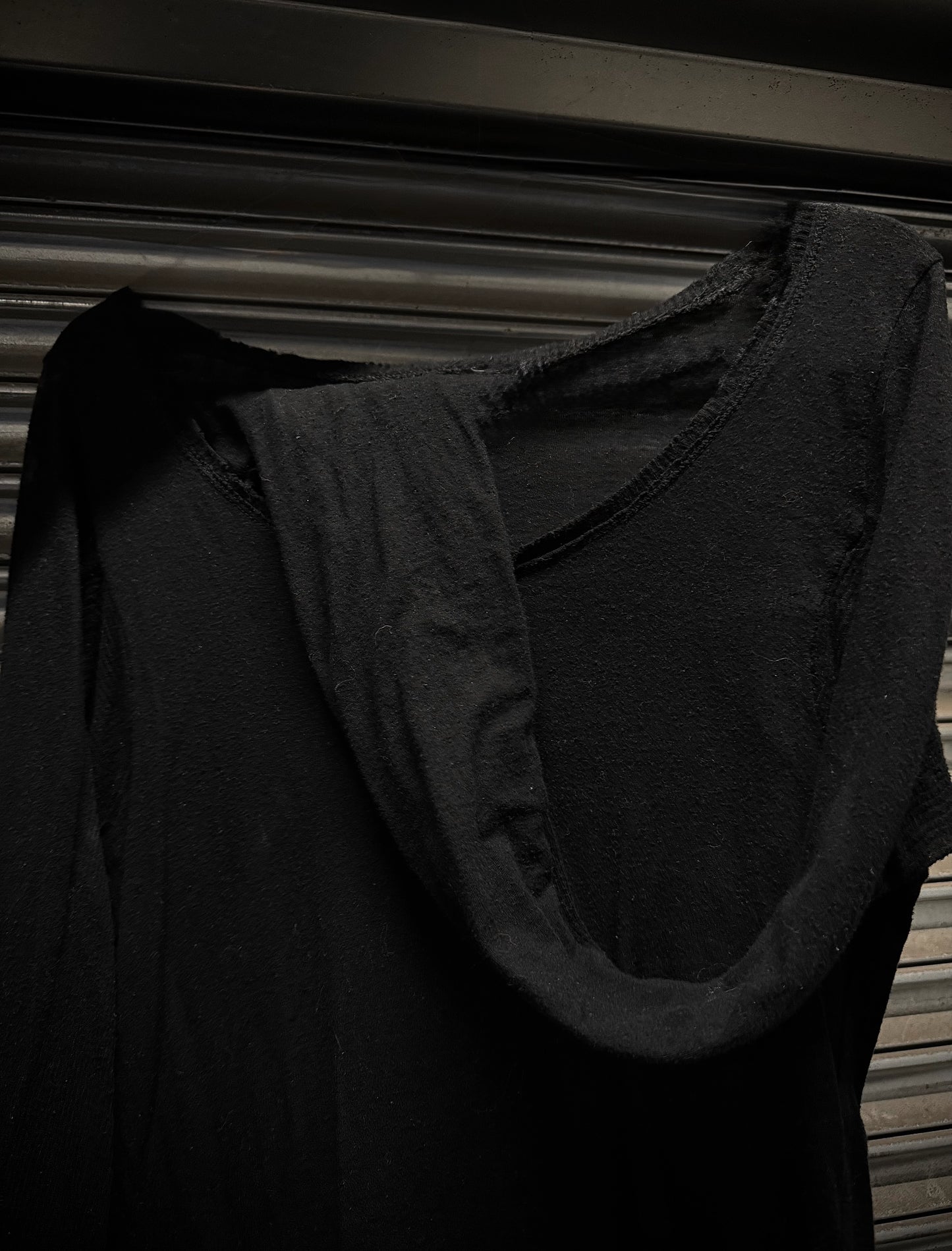 Black garment hanging against a dark background
