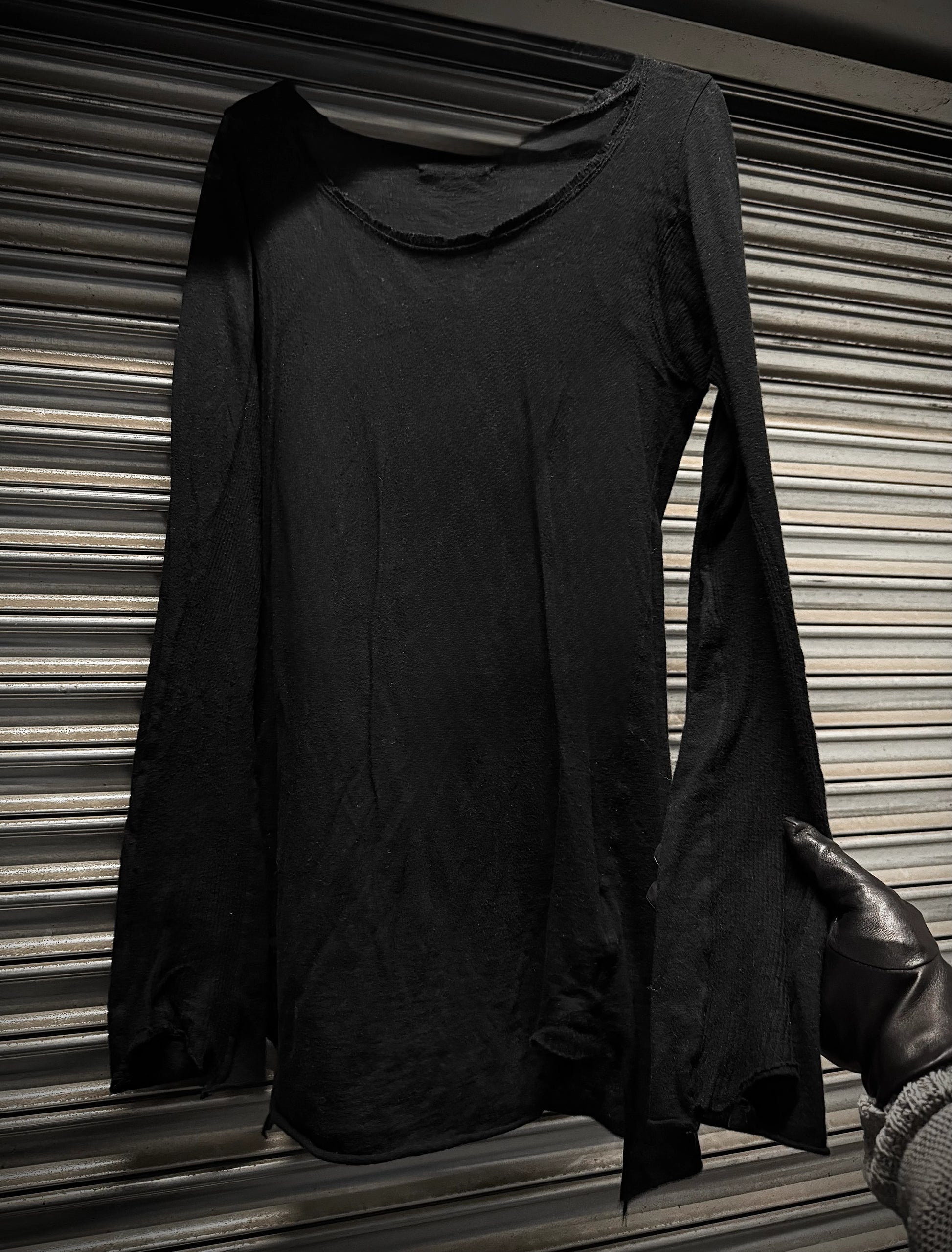 Black long-sleeve top with a hood on a striped background