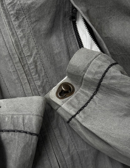Close-up of a button on a jacket with a zipper partially open.