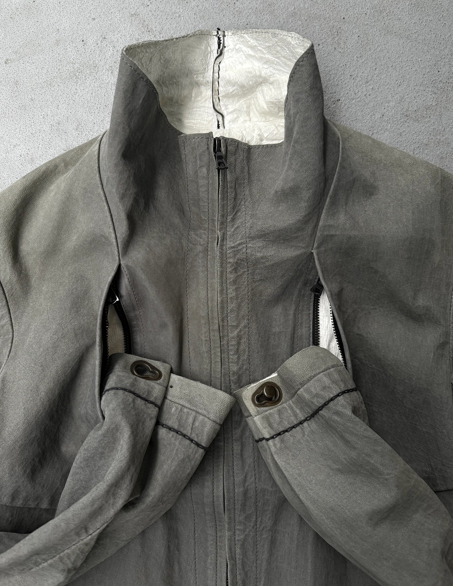 Gray coat with a zipper and button details on a gray background