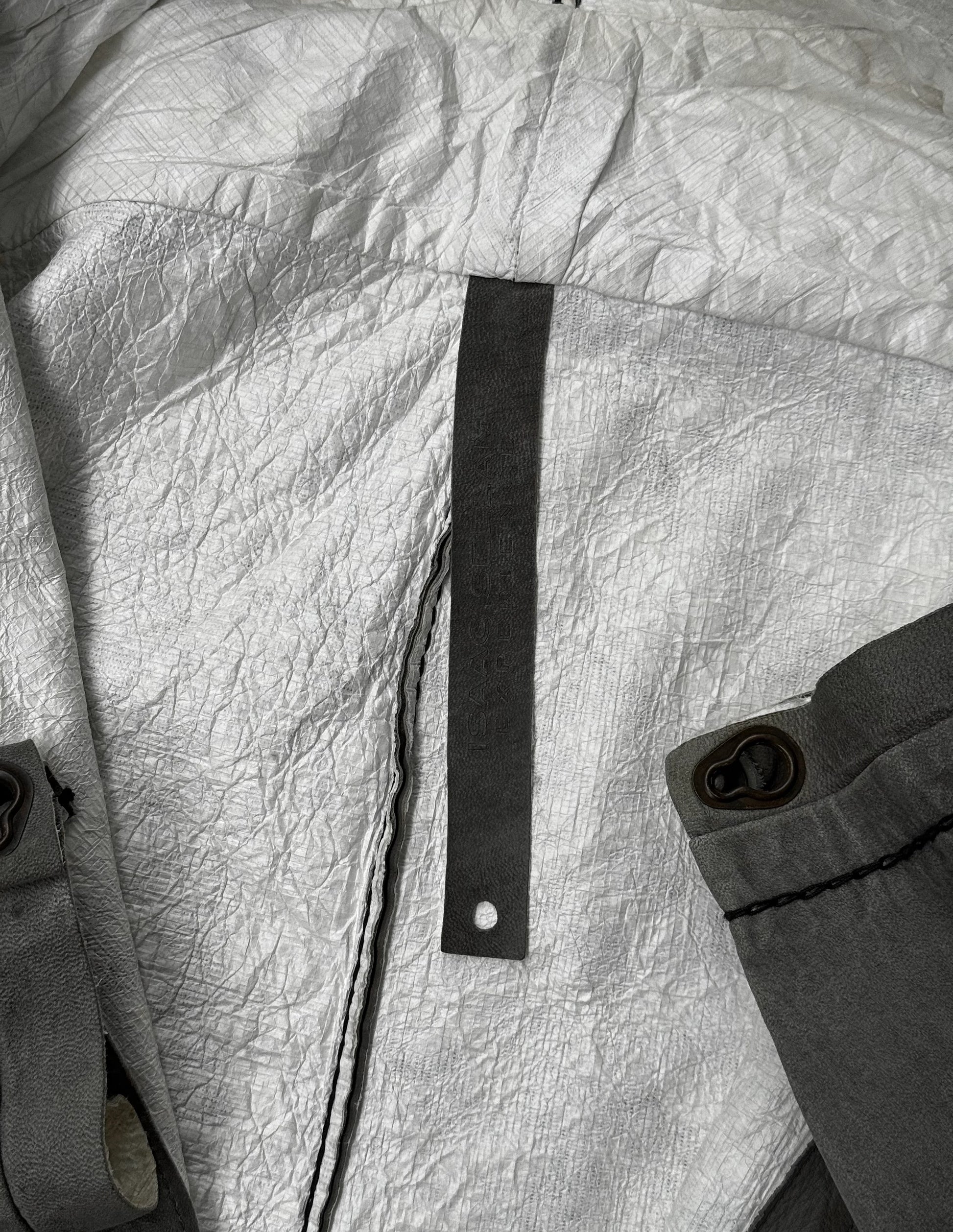 Close-up of a textured fabric surface with a black strap and button.