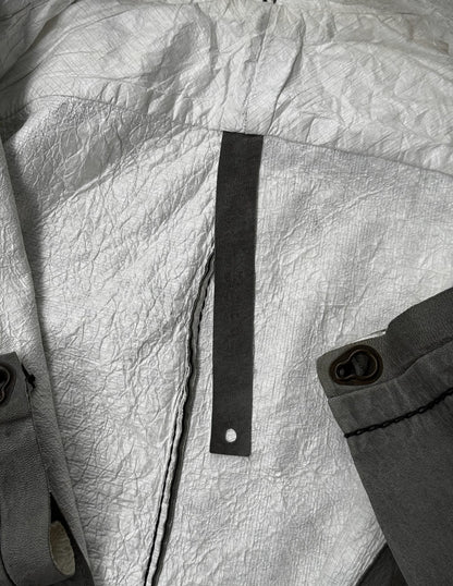 Close-up of a textured fabric surface with a black strap and button.