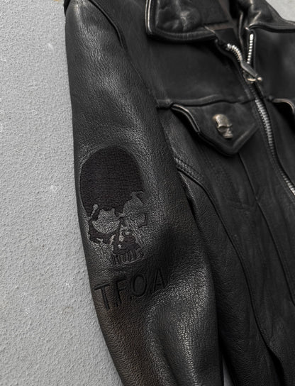 Black leather jacket with skull design and 'T.F.O.A.' branding on a gray background