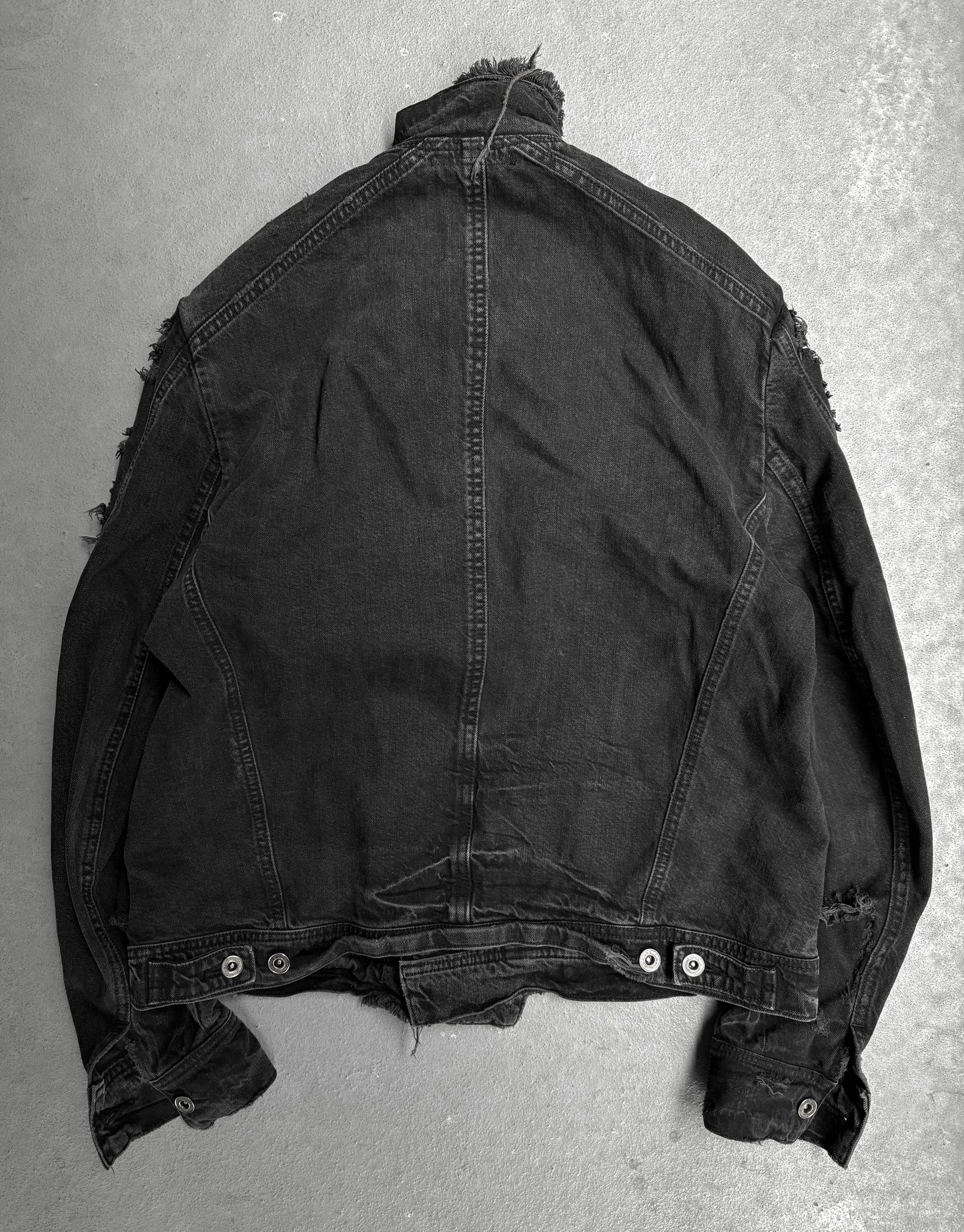 Black denim jacket on a gray textured background