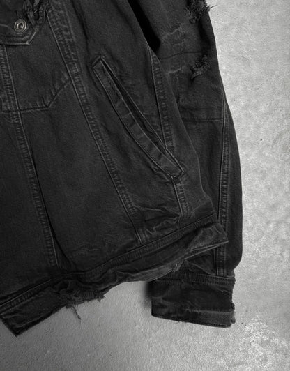 Black denim jacket on a gray concrete surface