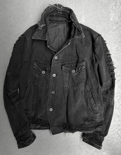 Ripped black denim jacket on a gray background
