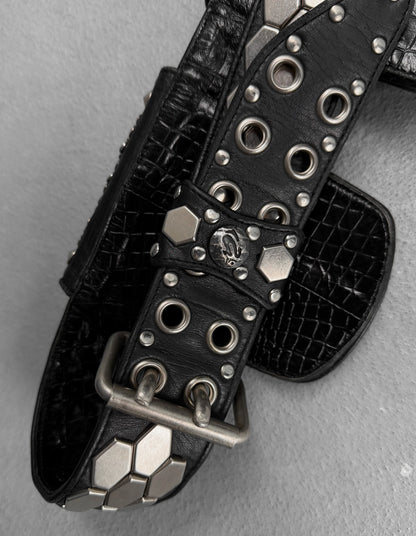 Black leather belt with silver studs and buckles on a gray background