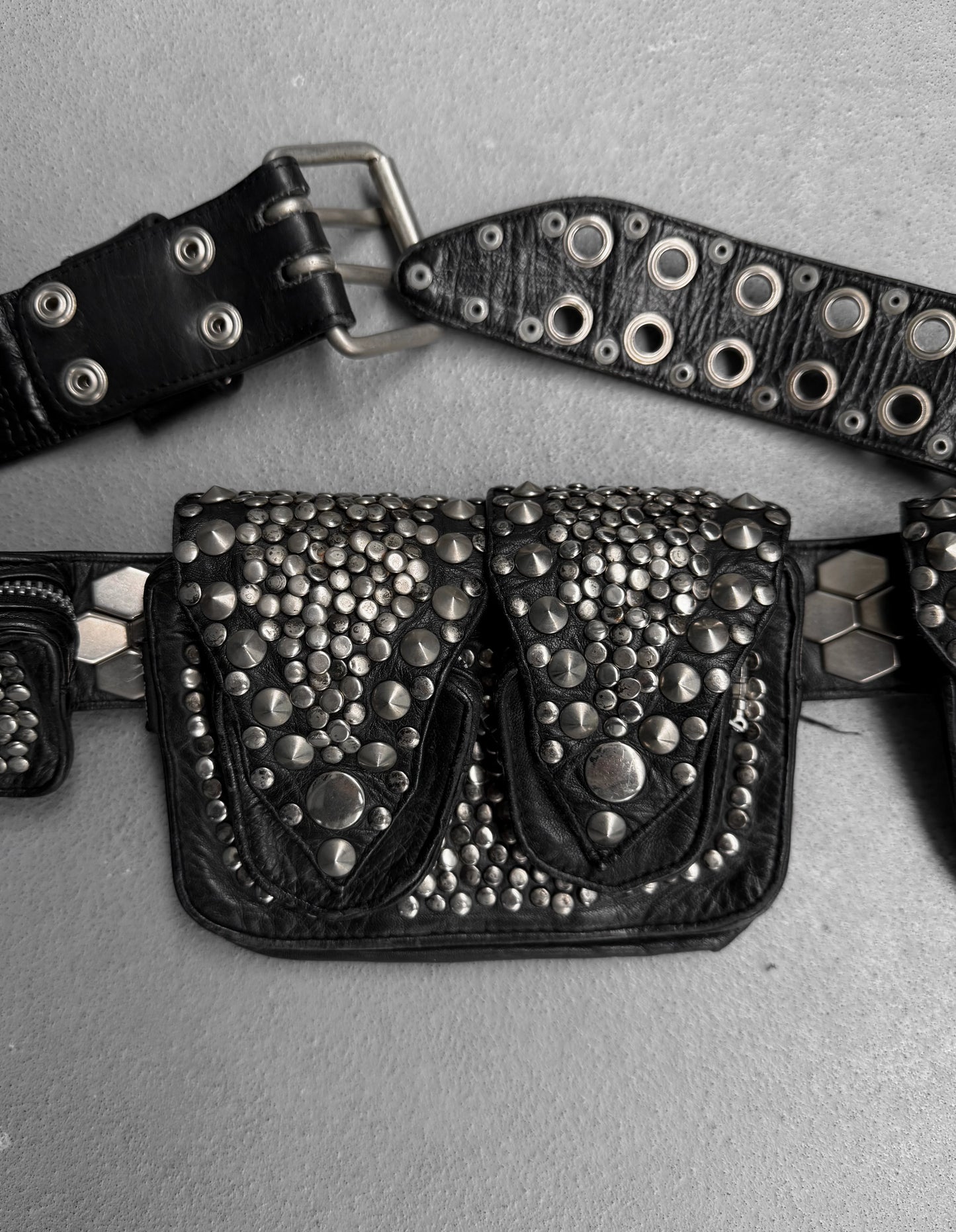 Black studded belt bag on a gray background