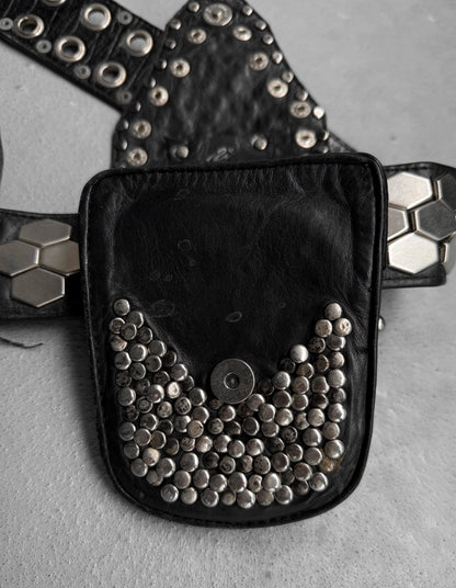 Black belt bag with silver studs on a gray surface