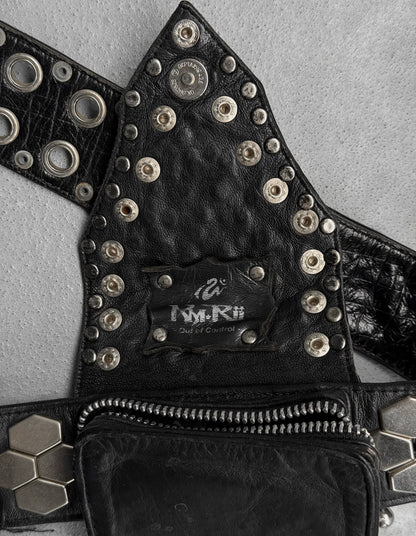 Black leather vest with studs and a brand label on a gray background