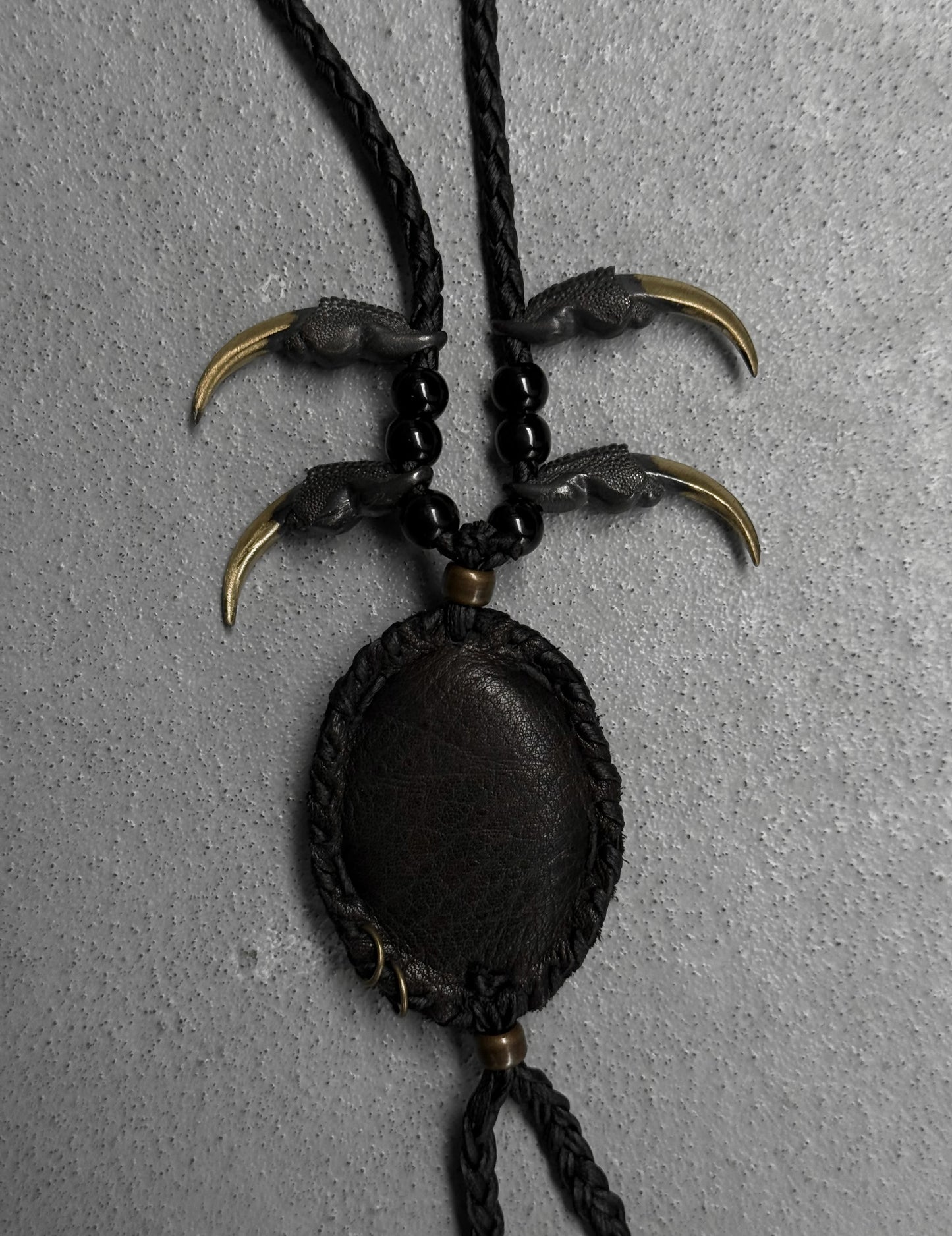 Necklace with claw-like pendants on a gray background