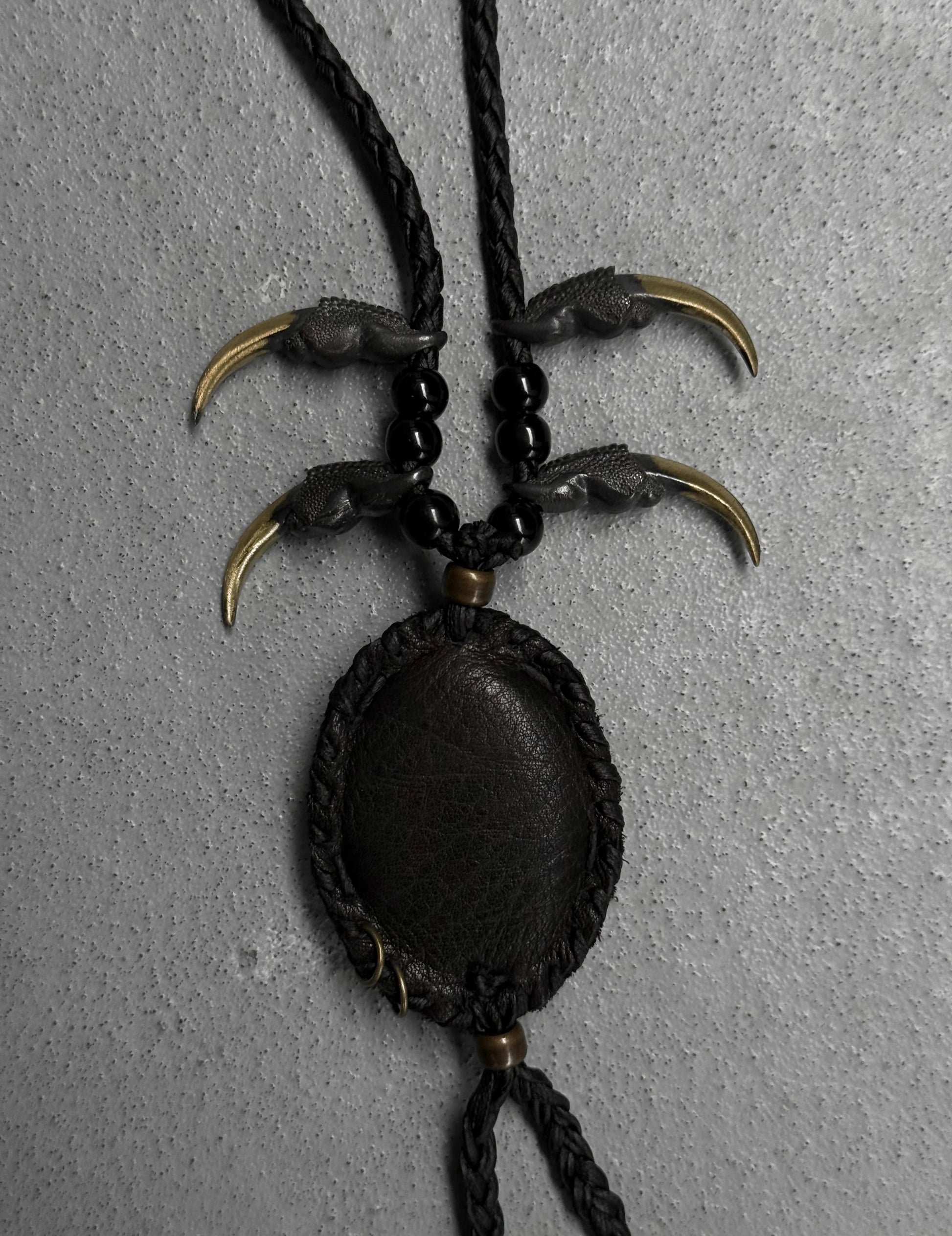 Necklace with claw-like pendants on a gray background