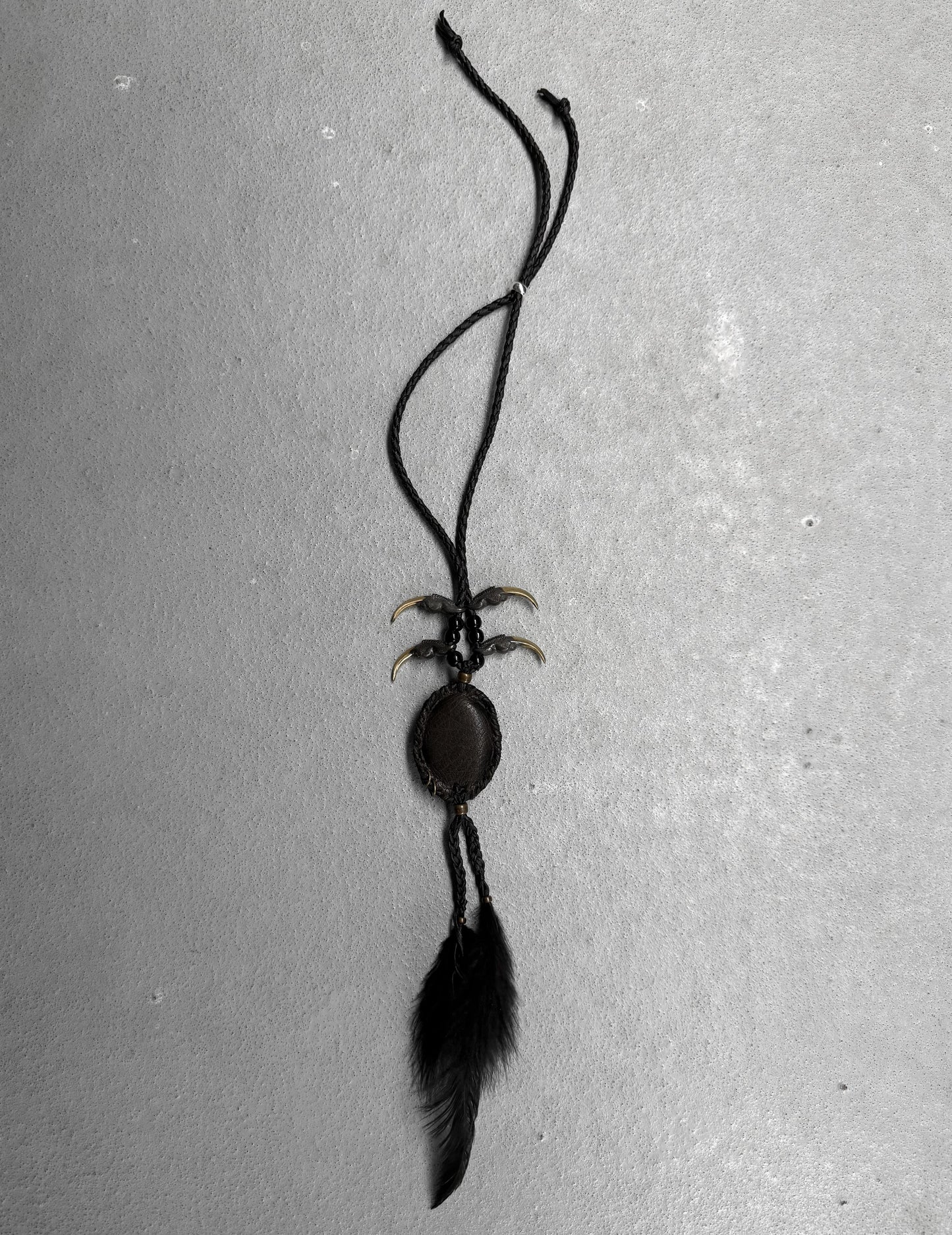 Black feathered necklace on a gray background