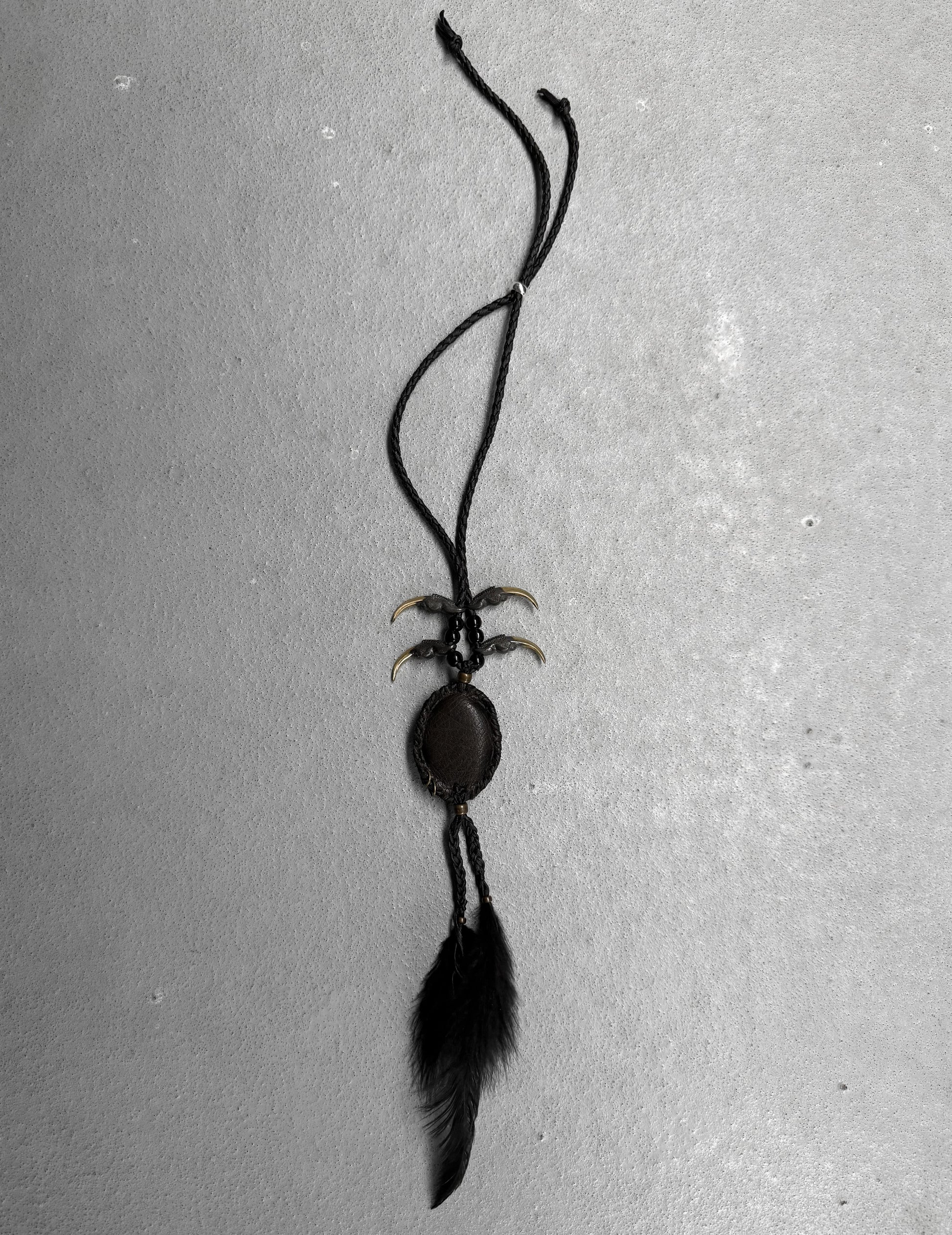 Black feathered necklace on a gray background
