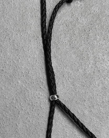 Close-up of a black rope with a metal clip on a gray concrete surface