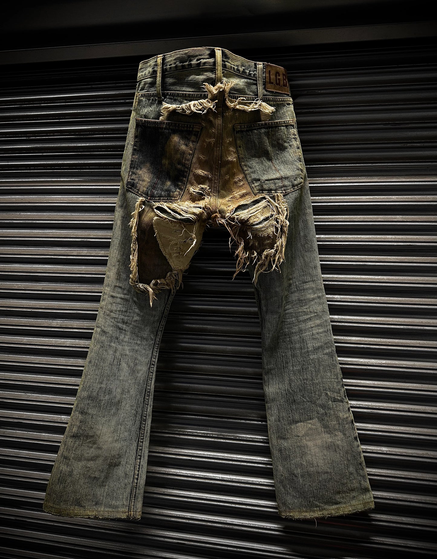 Rustic, distressed denim jeans against a metallic background