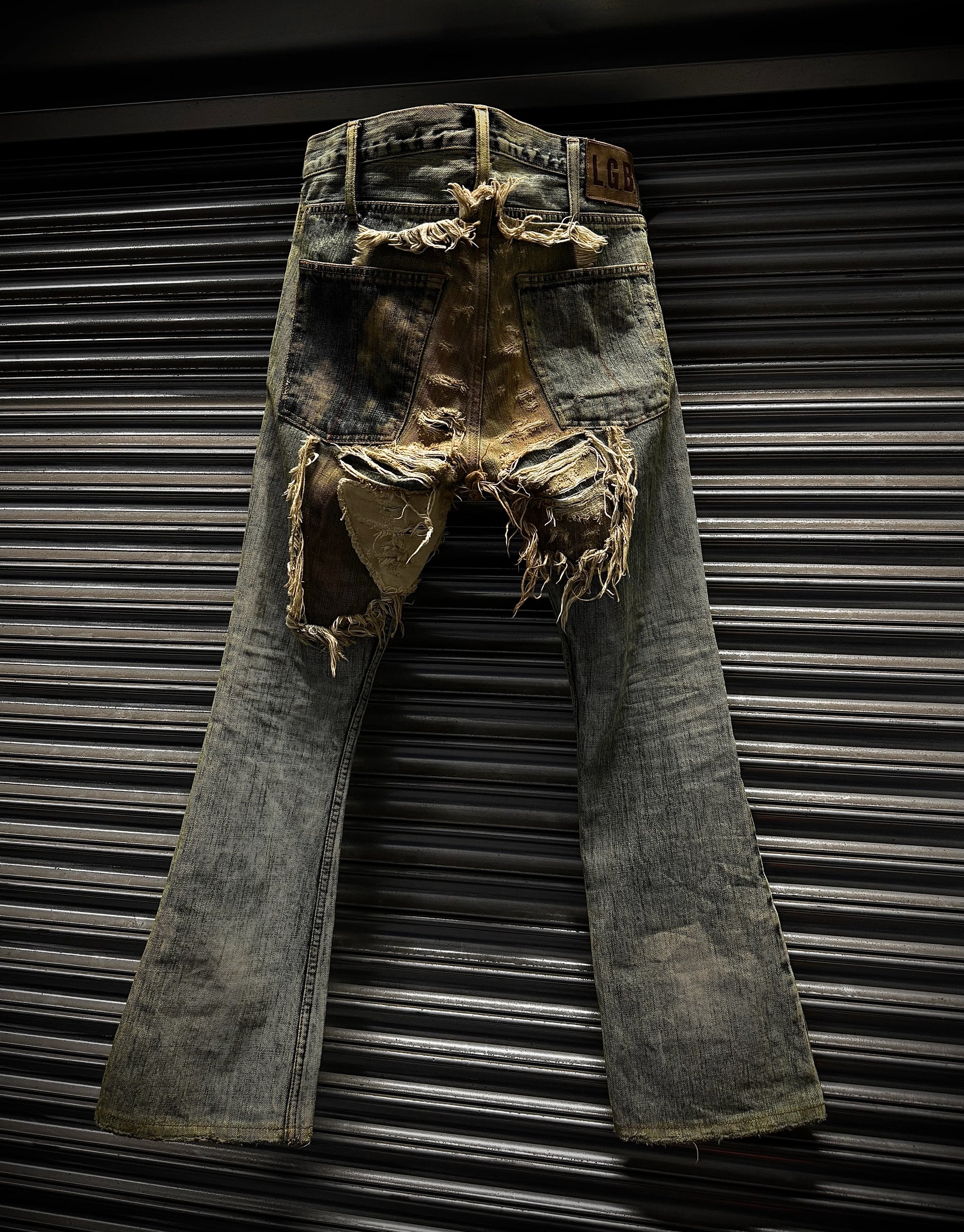 Rustic, distressed denim jeans against a metallic background
