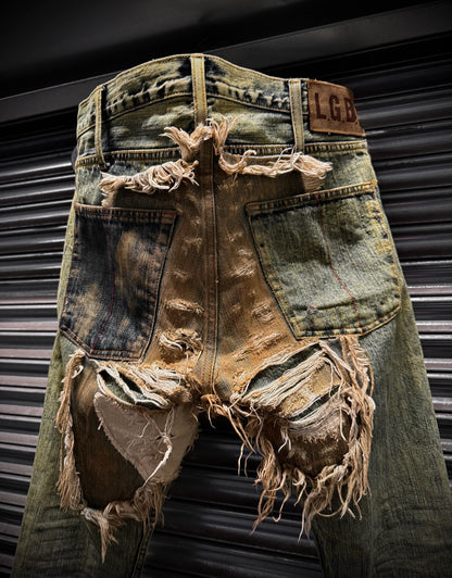 Distressed denim shorts with frayed edges against a metallic background