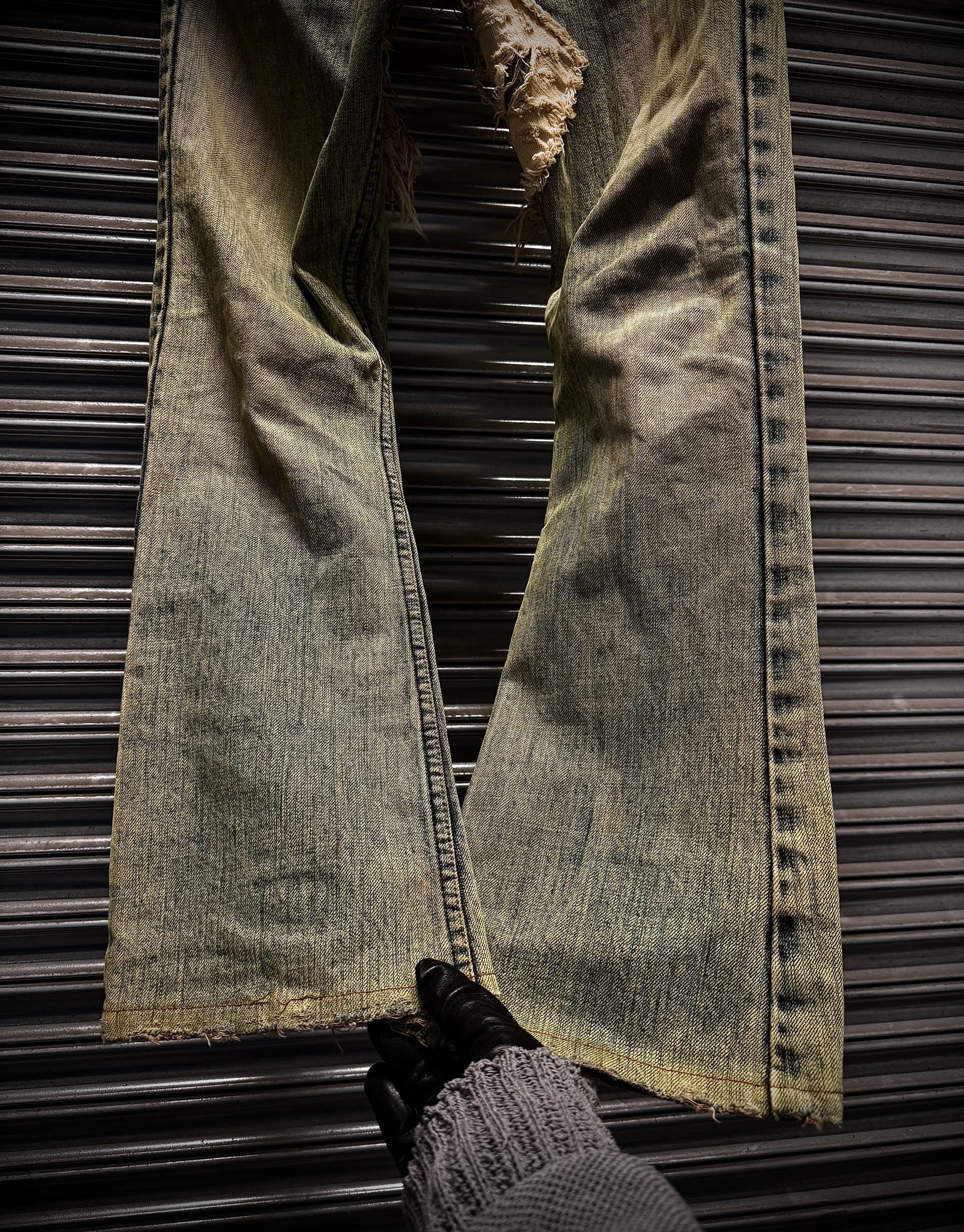 Pair of distressed jeans on a metallic surface