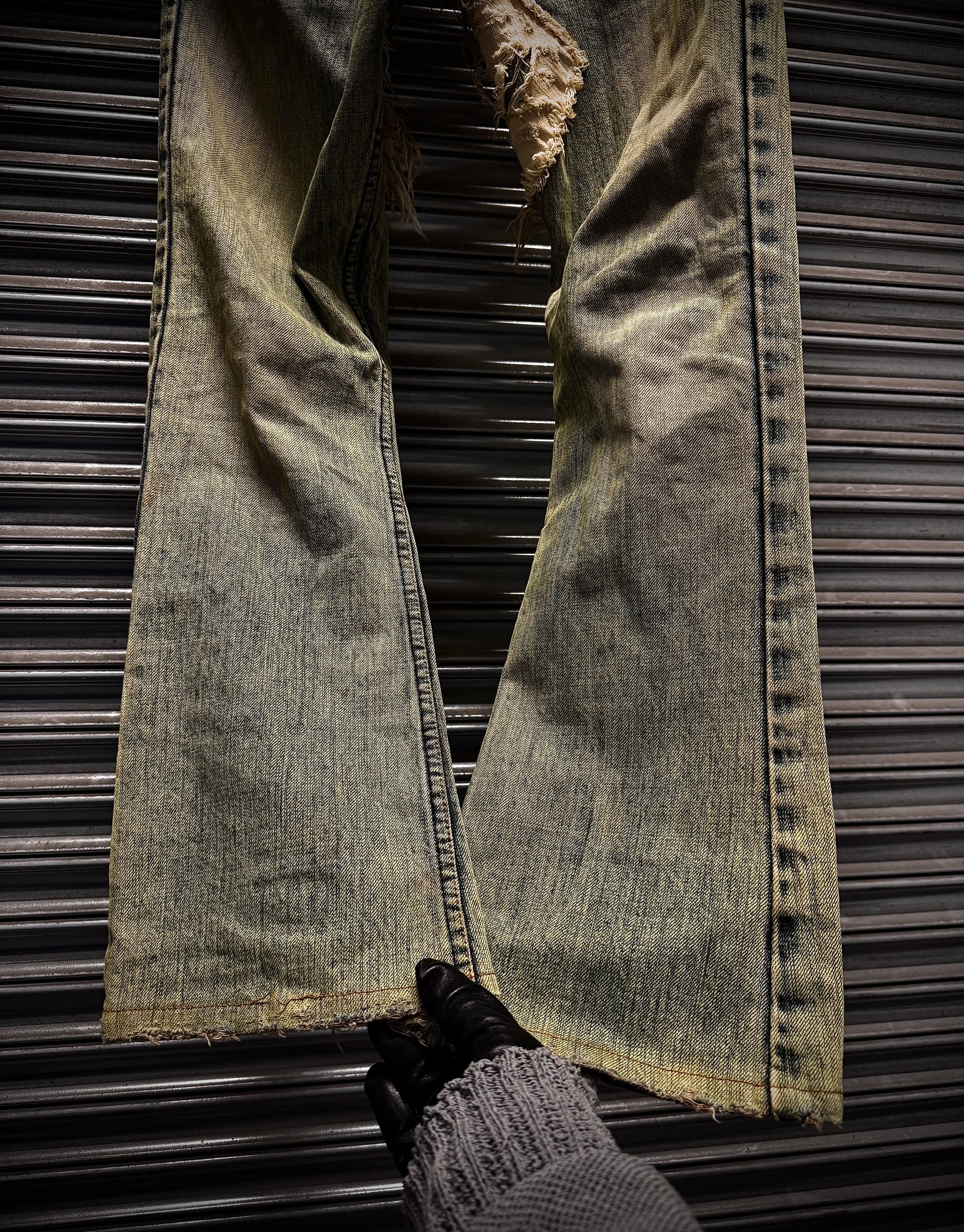 Pair of distressed jeans on a metallic surface