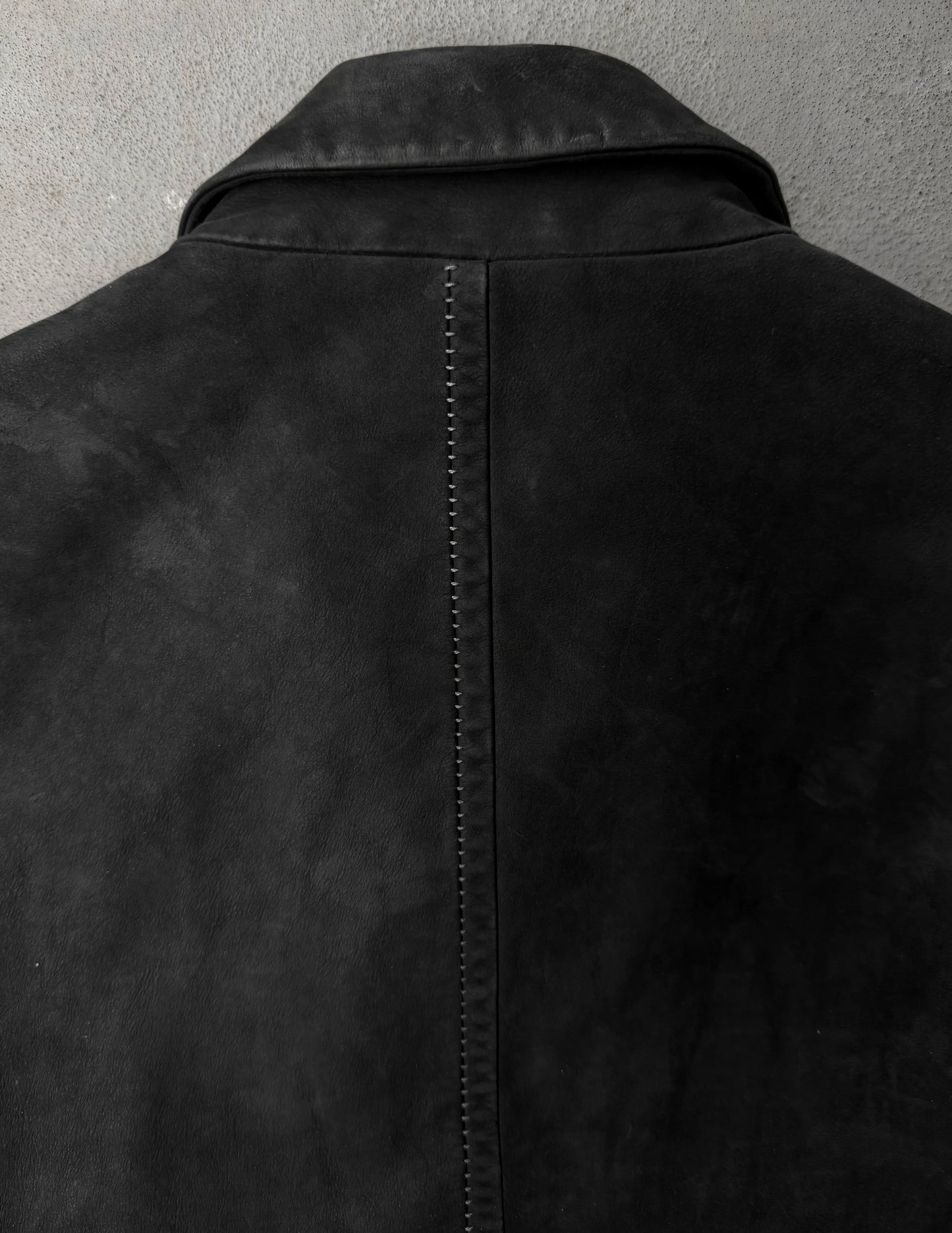 Close-up of a black leather jacket on a gray background