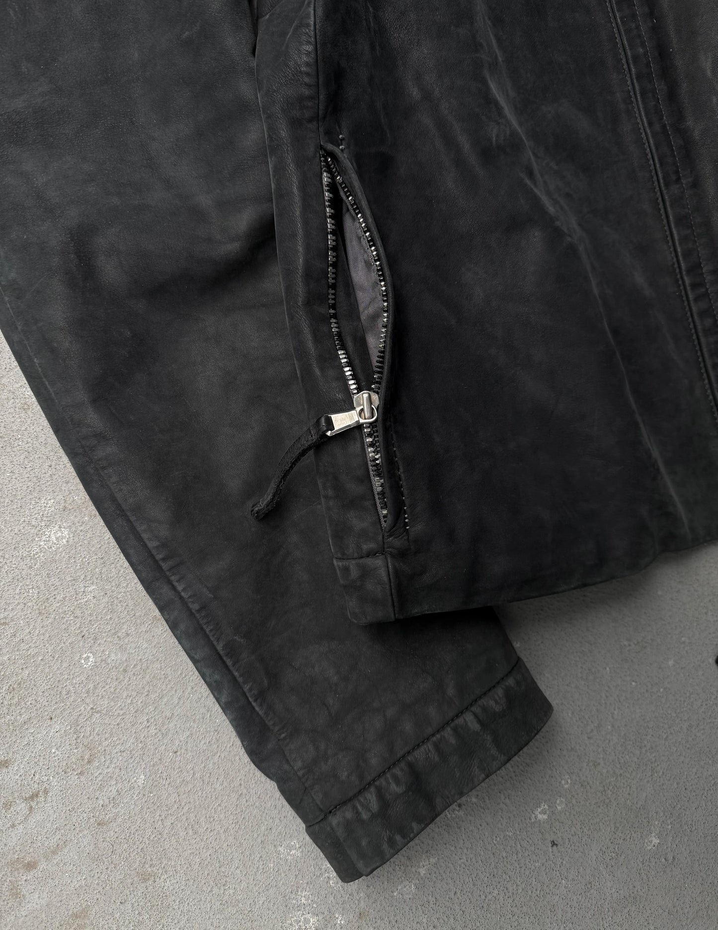 Close-up of a black jacket with a zipper on a gray surface