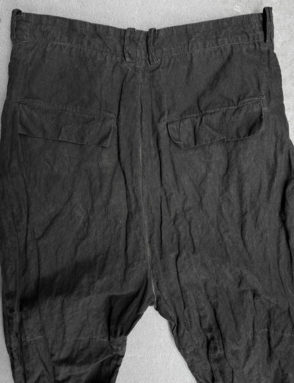 Dark gray pants with two front pockets on a light gray background