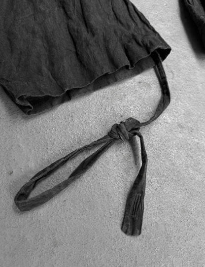 Black skirt with a tie on a light gray surface