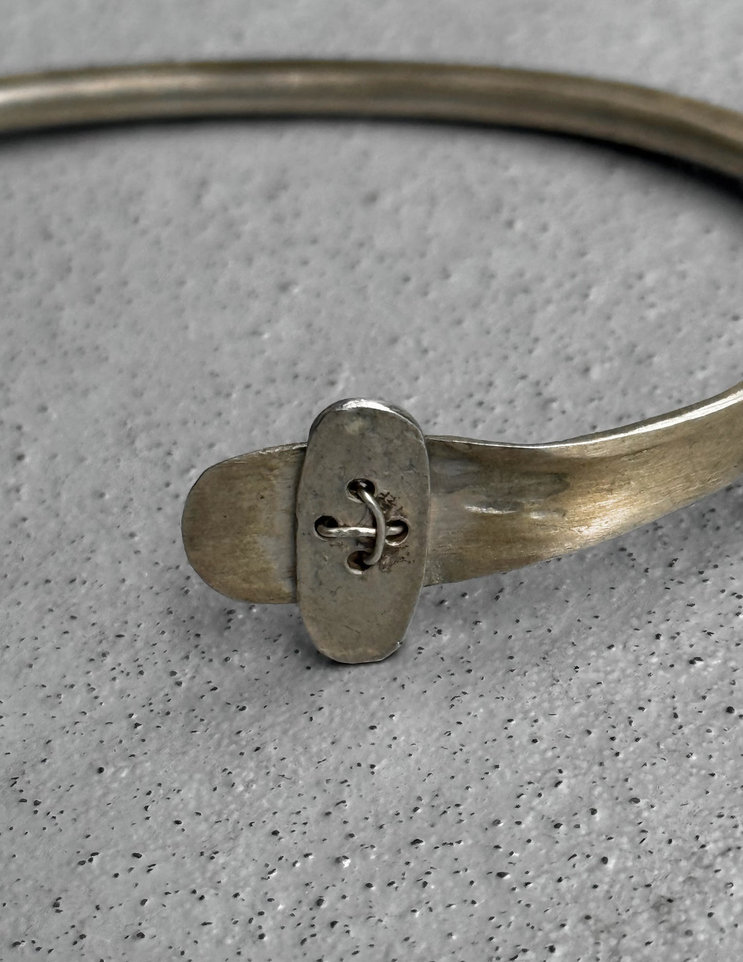 Silver bracelet with a decorative clasp on a gray background