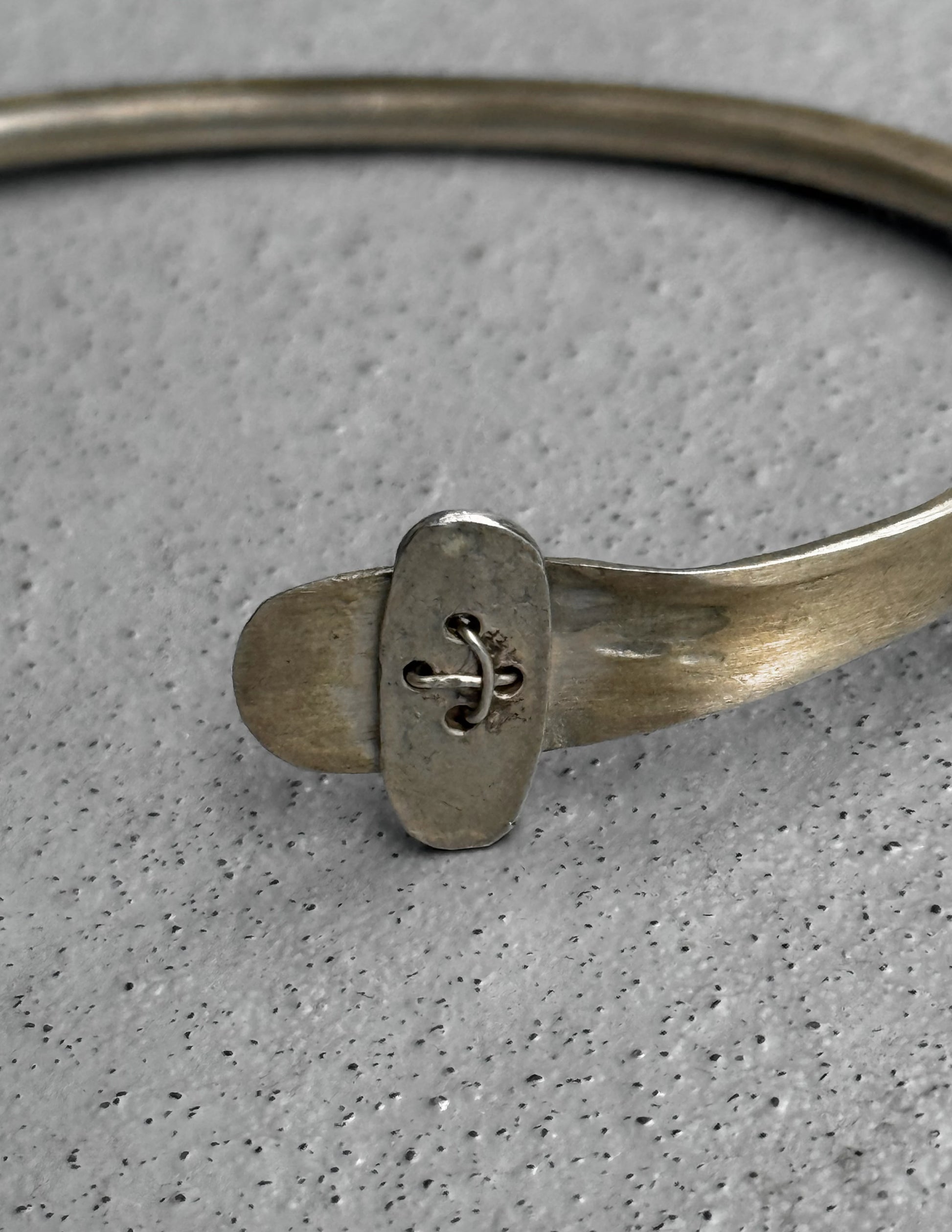 Silver bracelet with a decorative clasp on a gray background