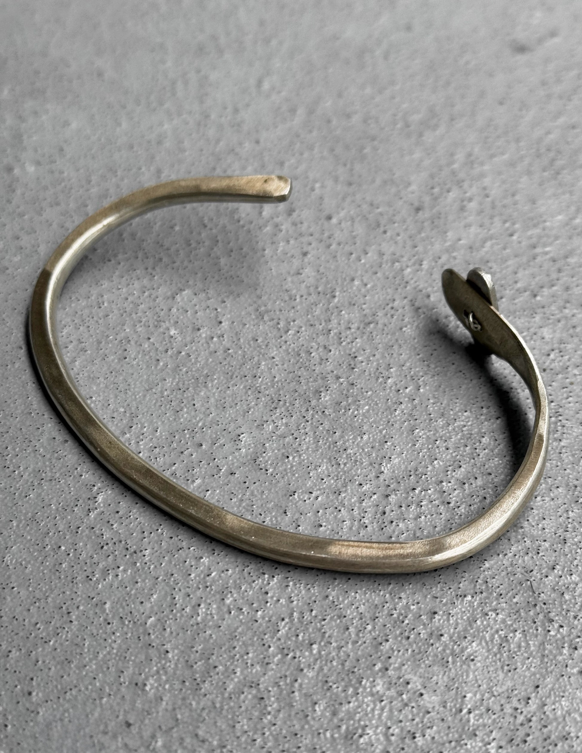 Silver bracelet on a textured gray surface